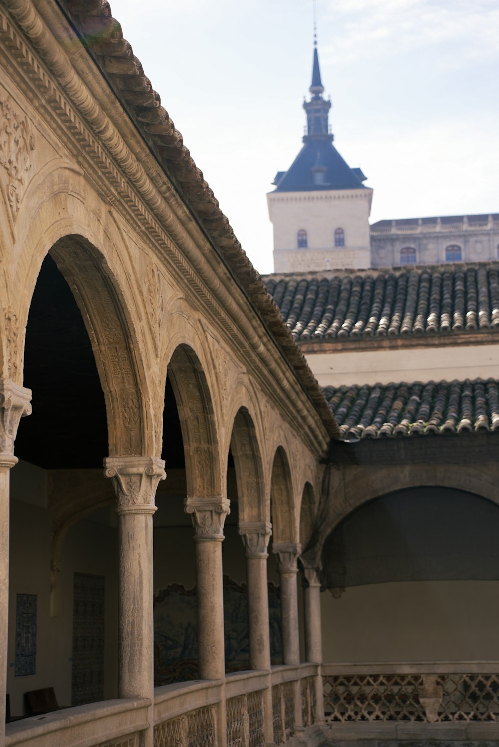 a building with arches and a clock tower in the background