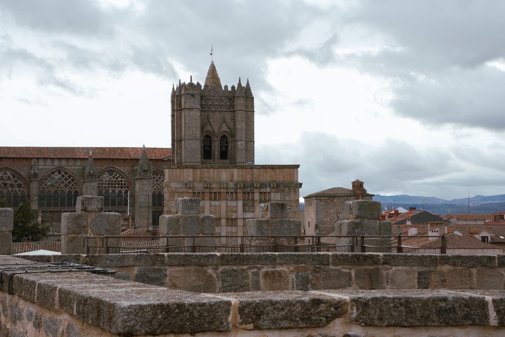 a stone wall with a clock tower in the background