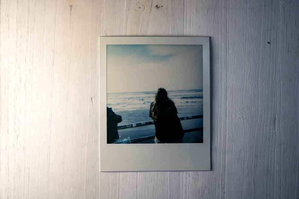 a polaroid picture of a woman standing on a beach