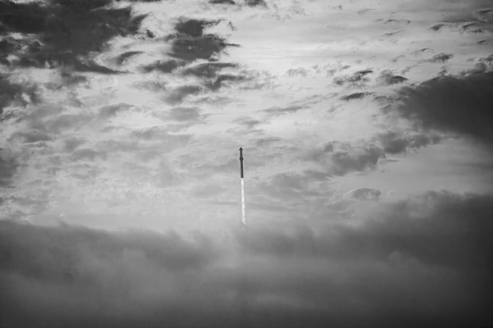 une photo en noir et blanc d’un avion dans le ciel