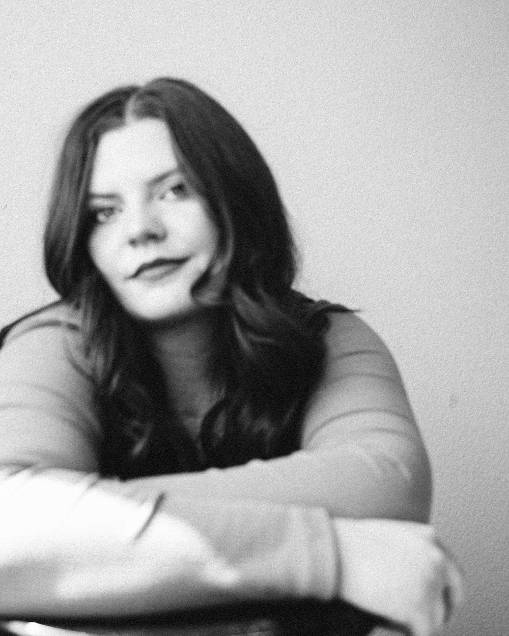 a black and white photo of a woman with her arms crossed