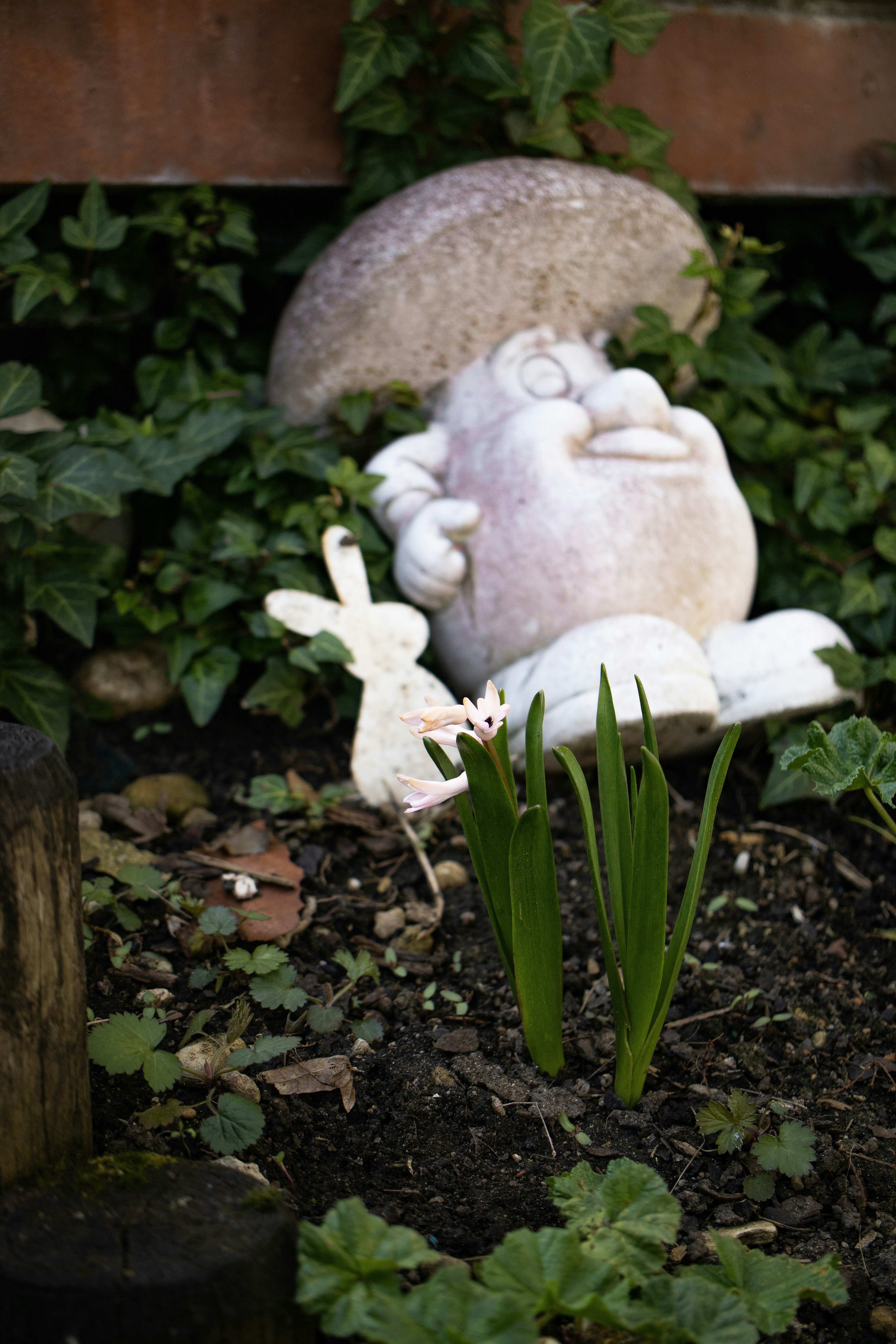 uma estátua de um coelho e um coelho sentado em um jardim