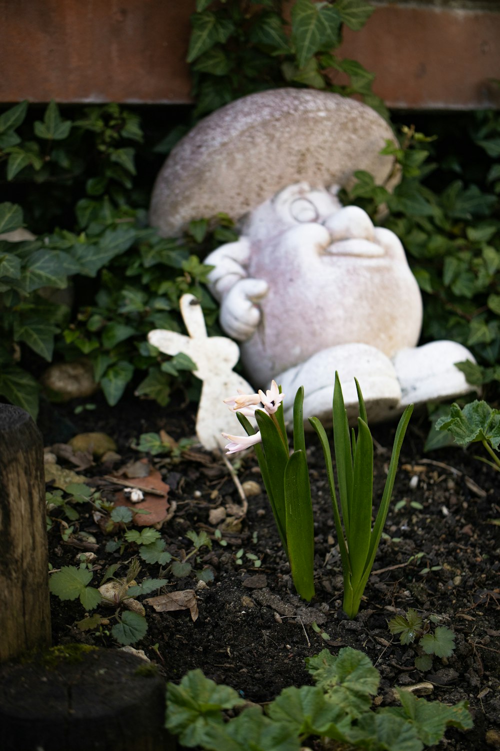 a statue of a bunny and a rabbit sitting in a garden
