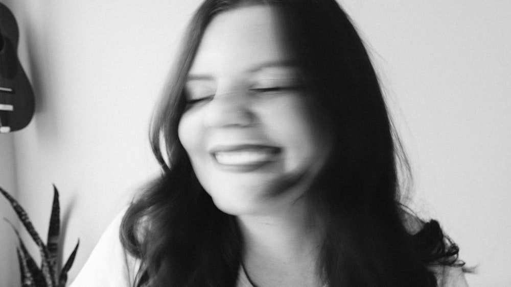 a black and white photo of a woman laughing