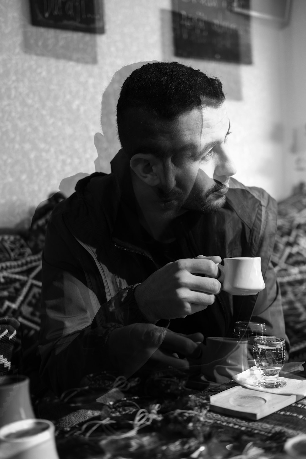 a black and white photo of a man sitting at a table