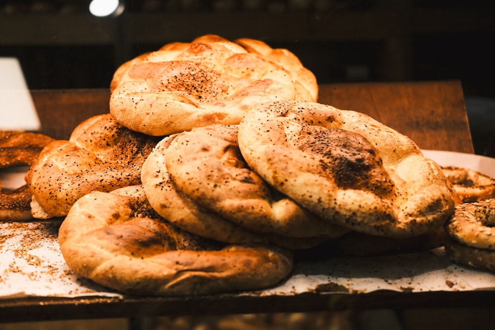 a pile of bagels sitting on top of a table