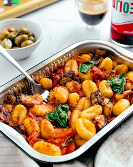 a dish of pasta with spinach and olives