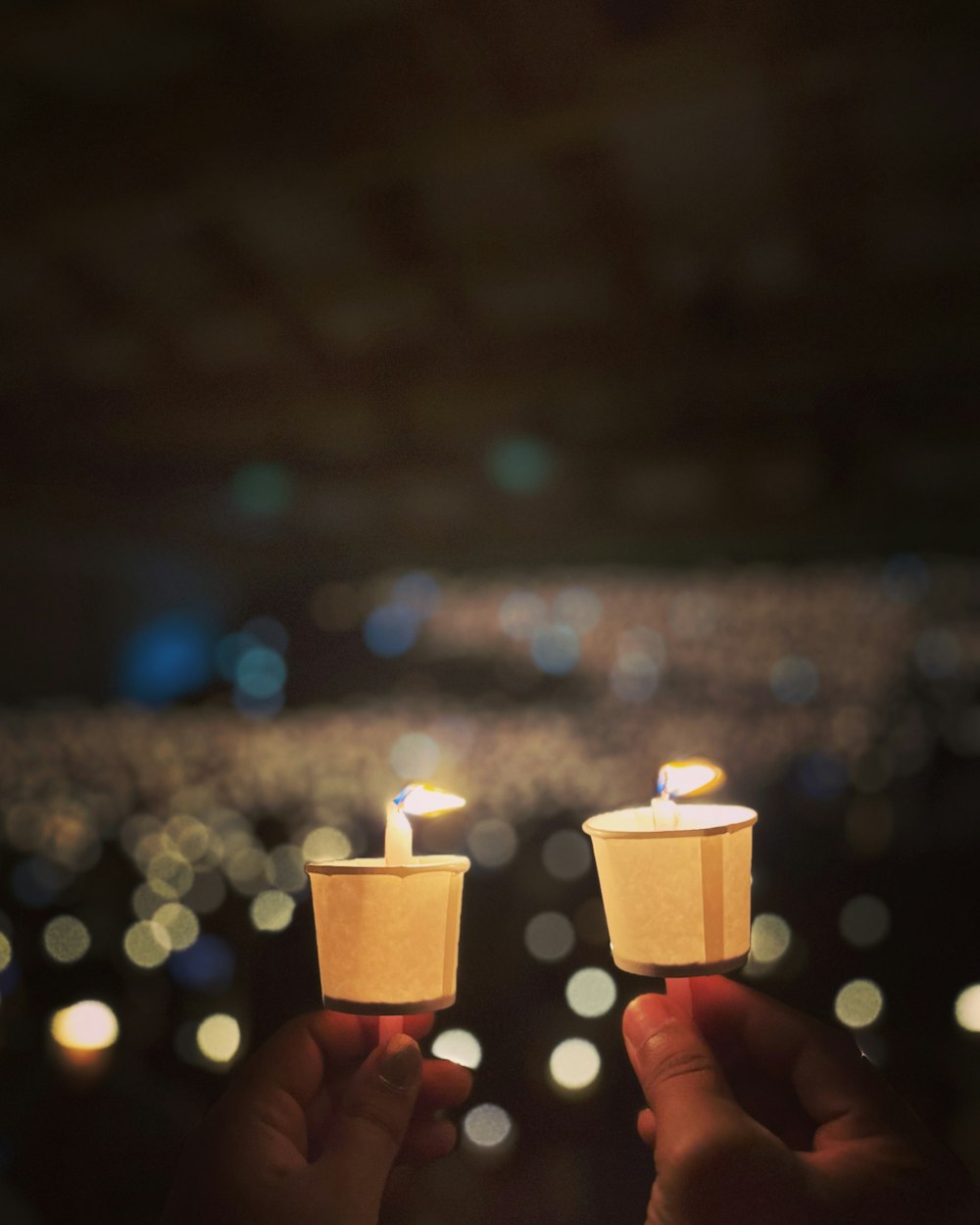 two people holding small candles in their hands