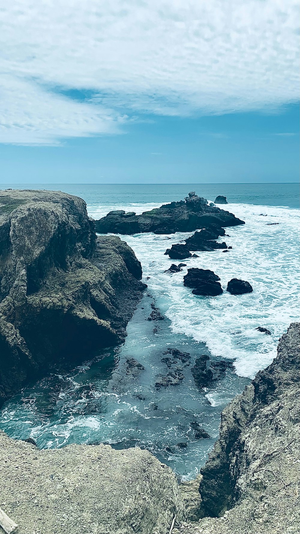 a bench sitting on the edge of a cliff overlooking the ocean