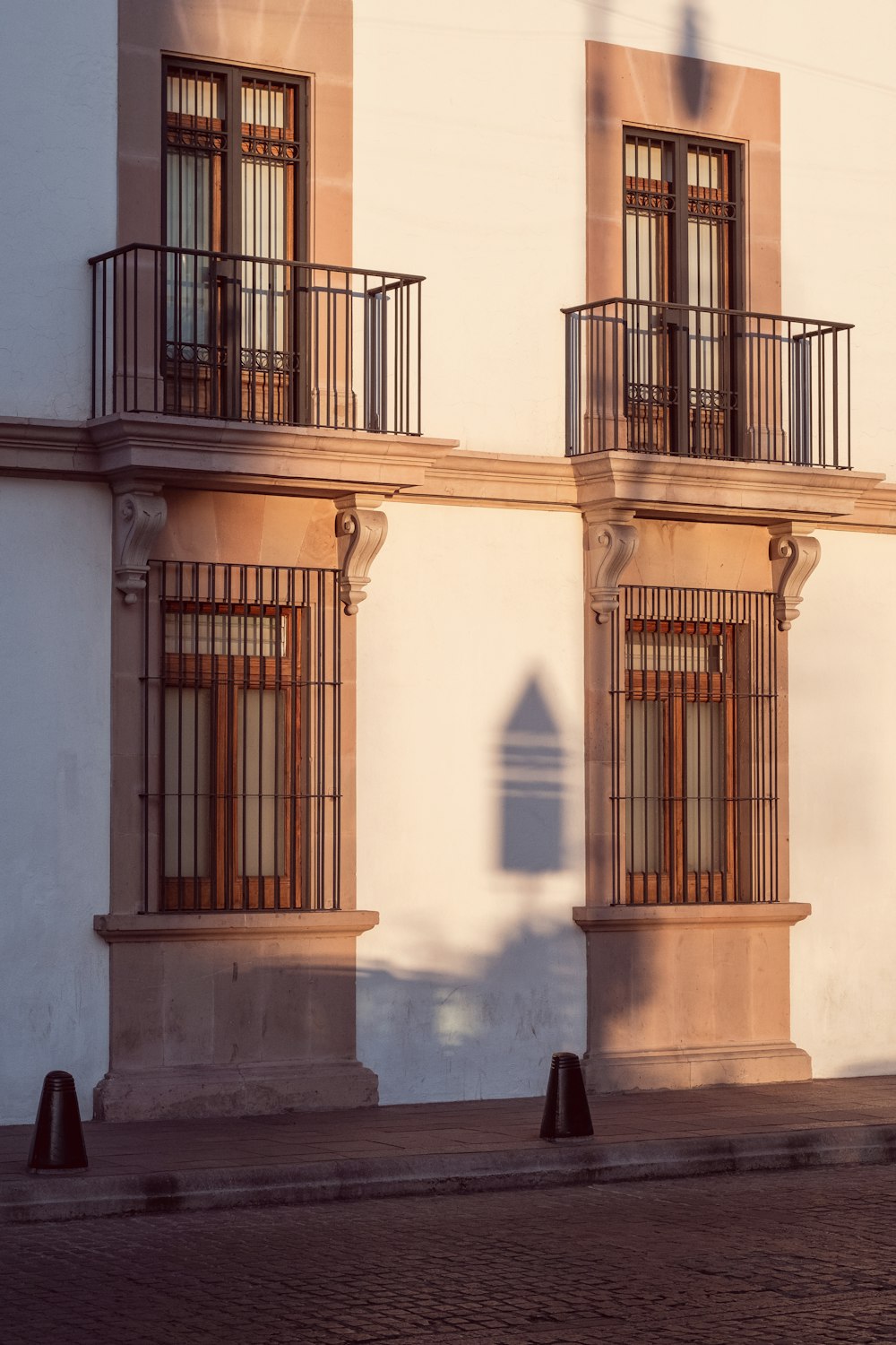 a white building with two balconies and a clock