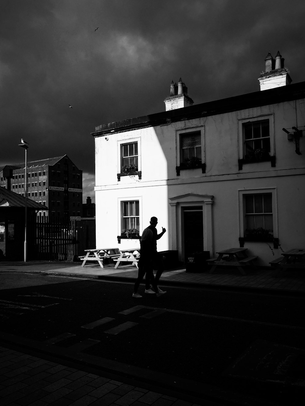 a black and white photo of a person walking down a street