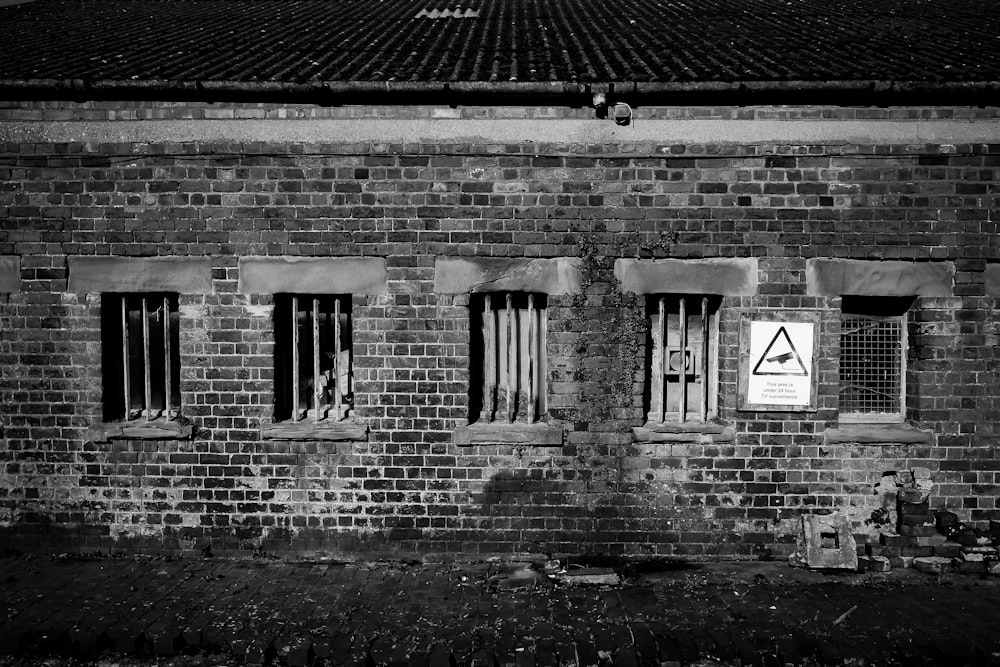a black and white photo of a brick building with barred windows