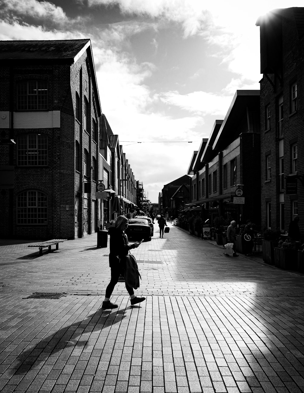 a black and white photo of a person walking down a street