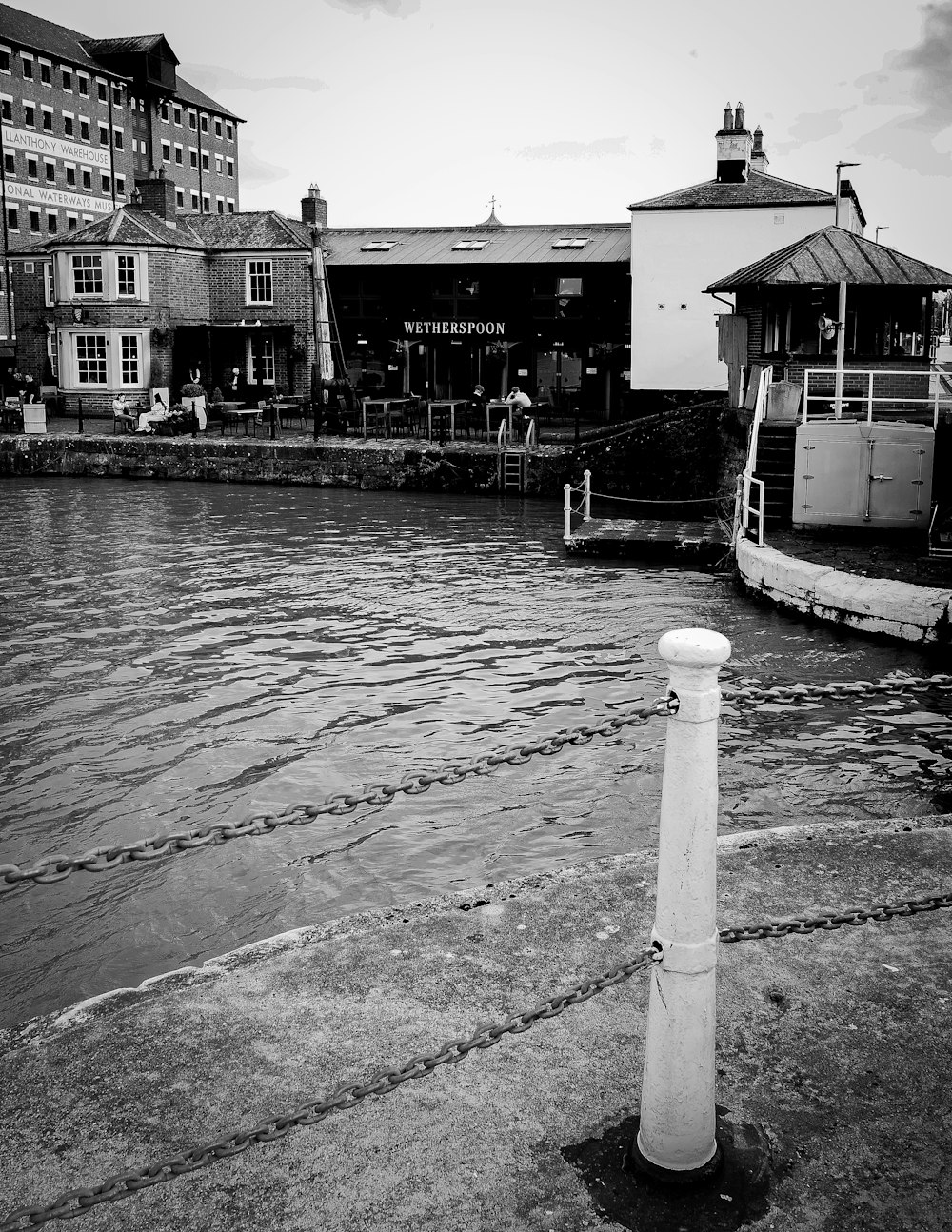 a white pole sitting in the middle of a body of water