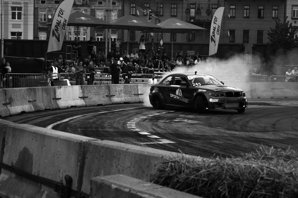 a black and white photo of a car on a track