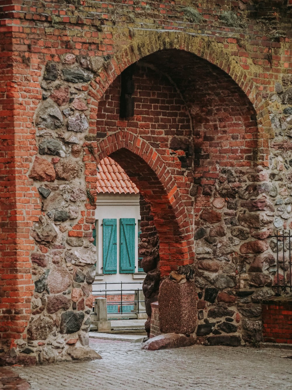 a brick building with a blue door and a stone walkway