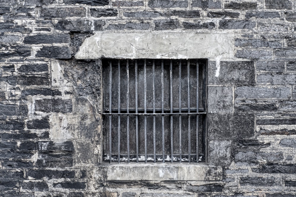 a brick wall with a barred window and bars