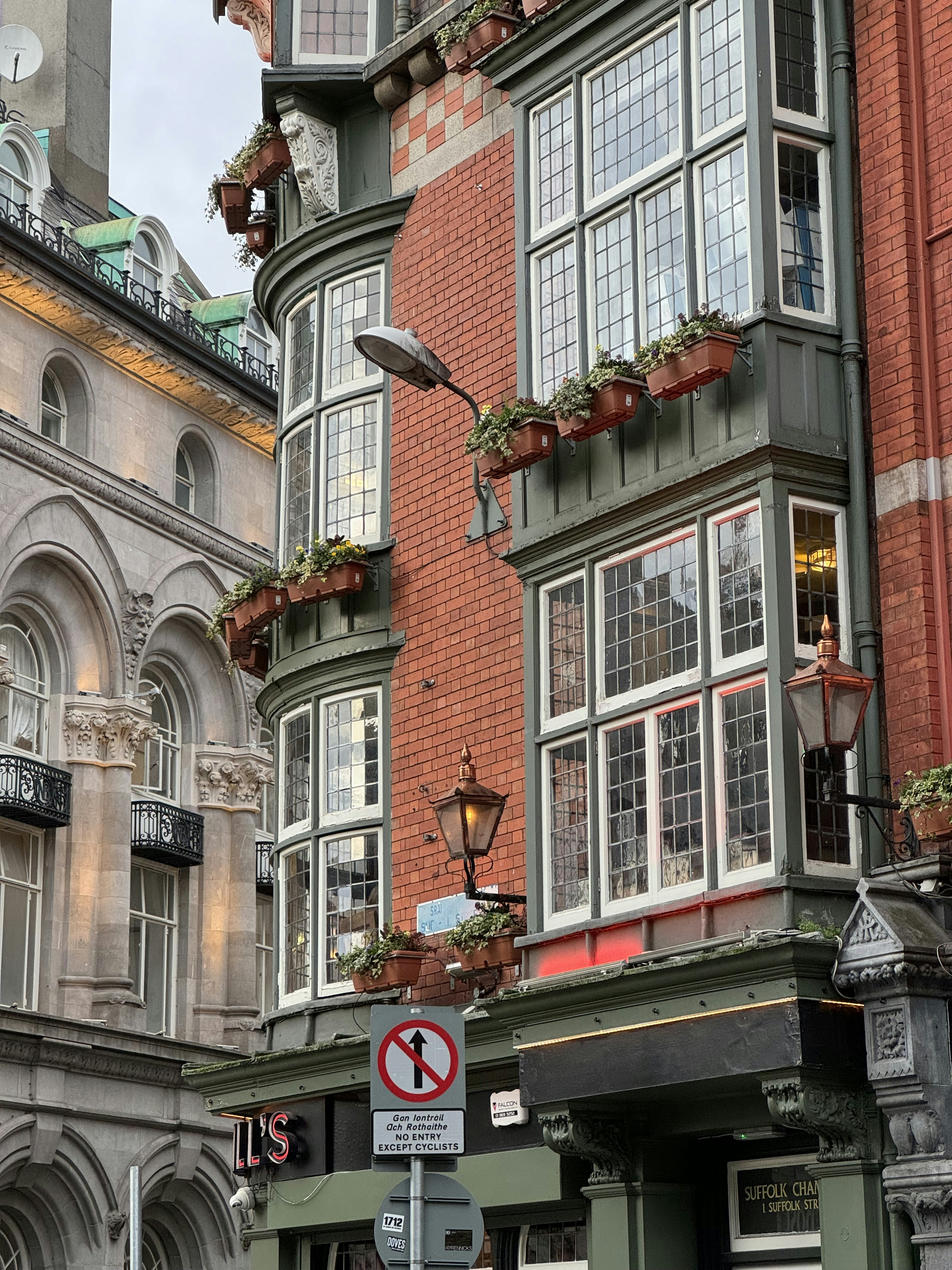 a tall building with many windows and a clock on the side of it