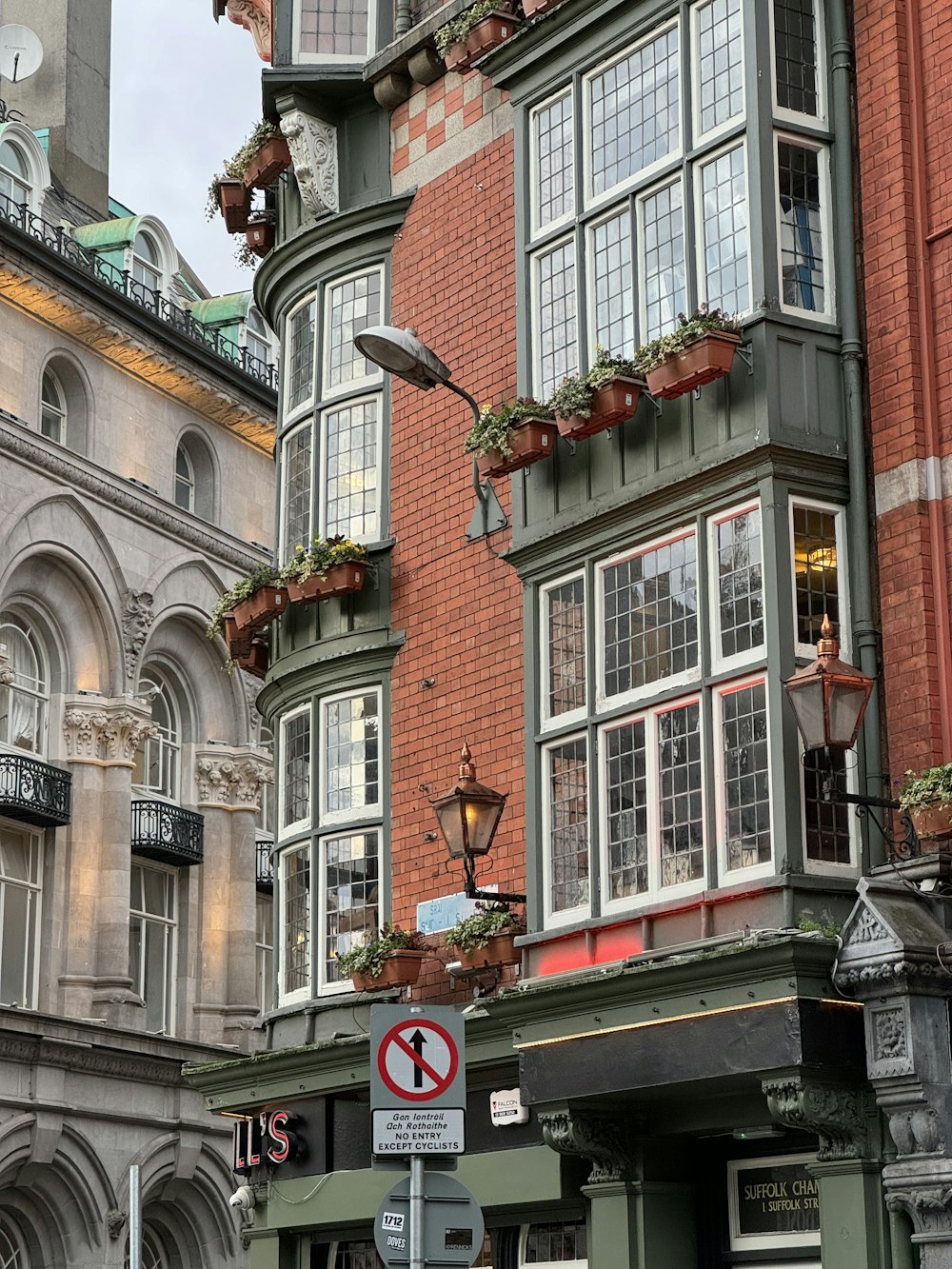 a tall building with many windows and a clock on the side of it