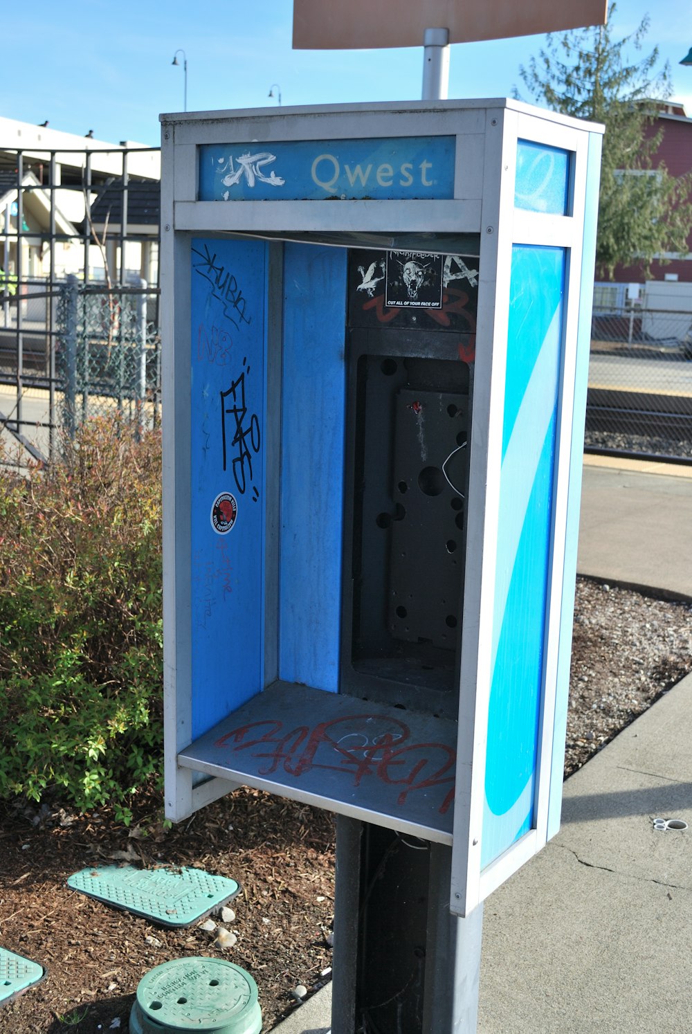 a blue and white box sitting on the side of a road