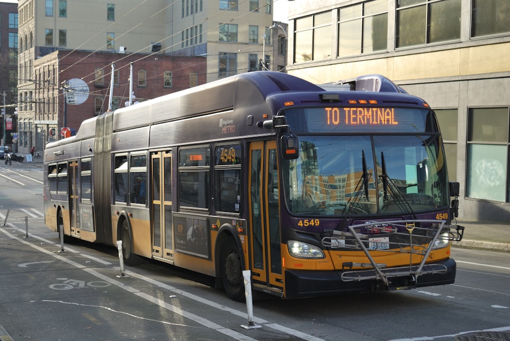 a city bus driving down a street next to tall buildings