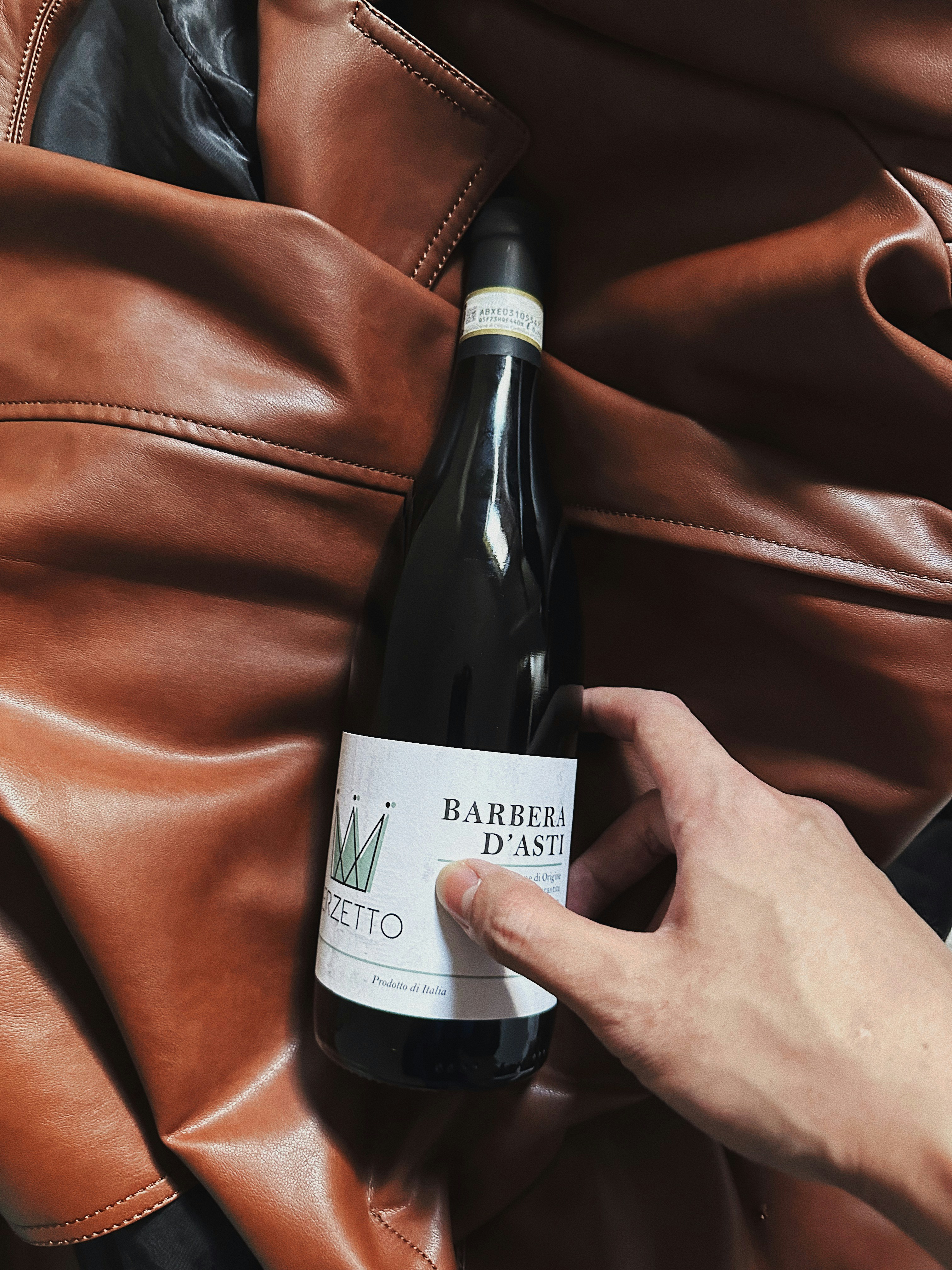 a person is holding a bottle of wine