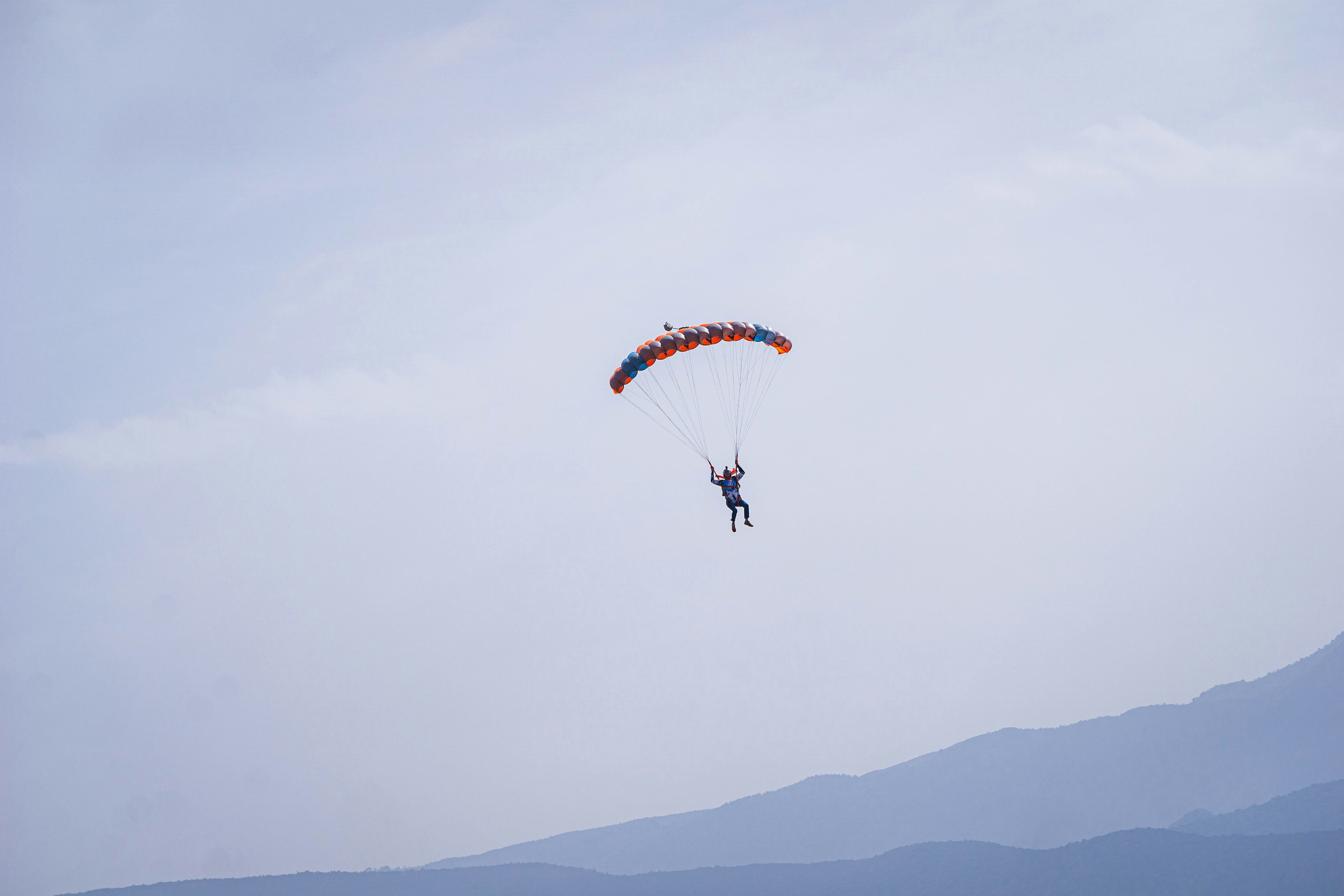 山々を背景に空をパラセーリングしている人