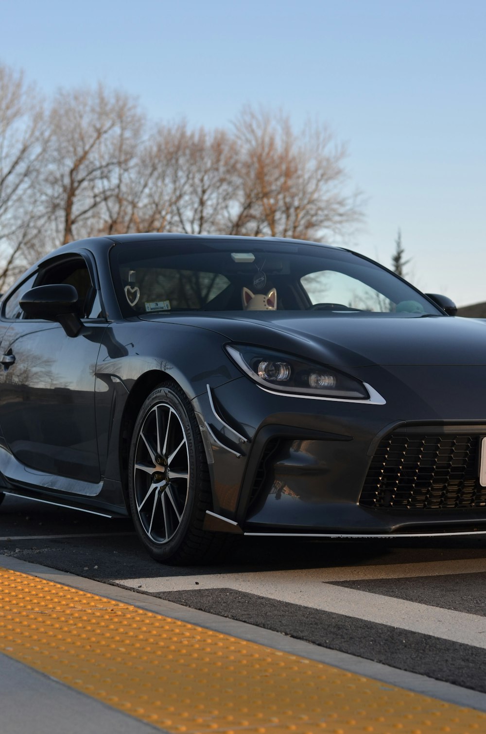 a gray sports car parked in a parking lot