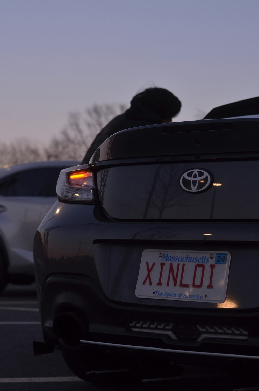 a car parked in a parking lot next to another car