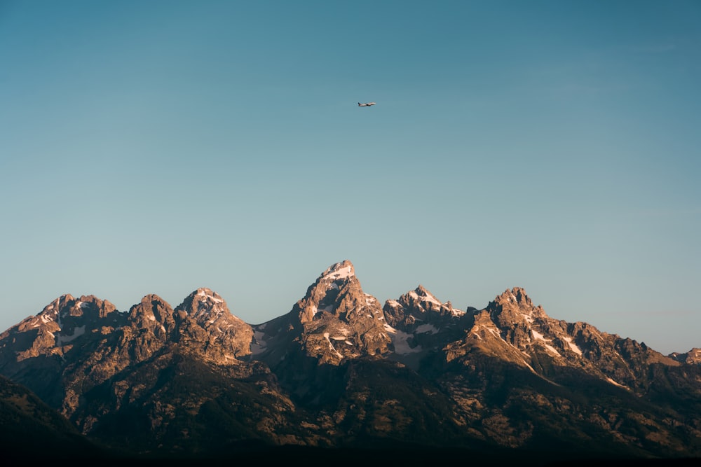a plane is flying over a mountain range