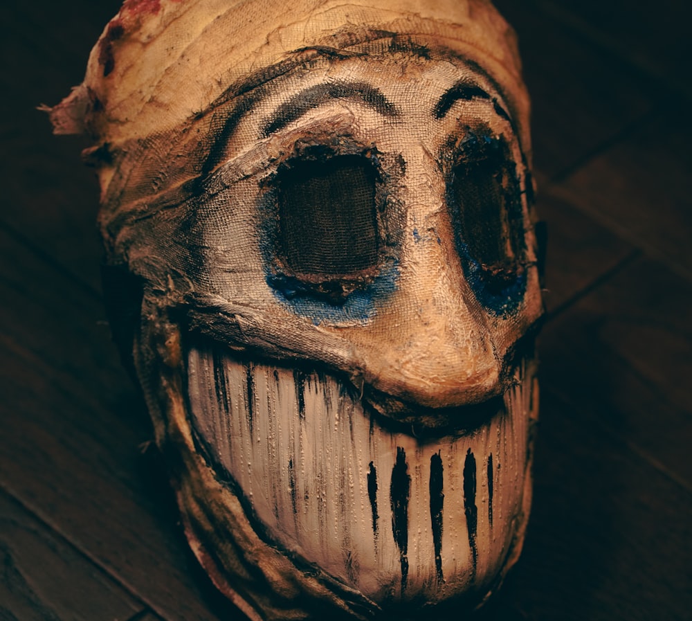 a wooden mask with a face painted on it
