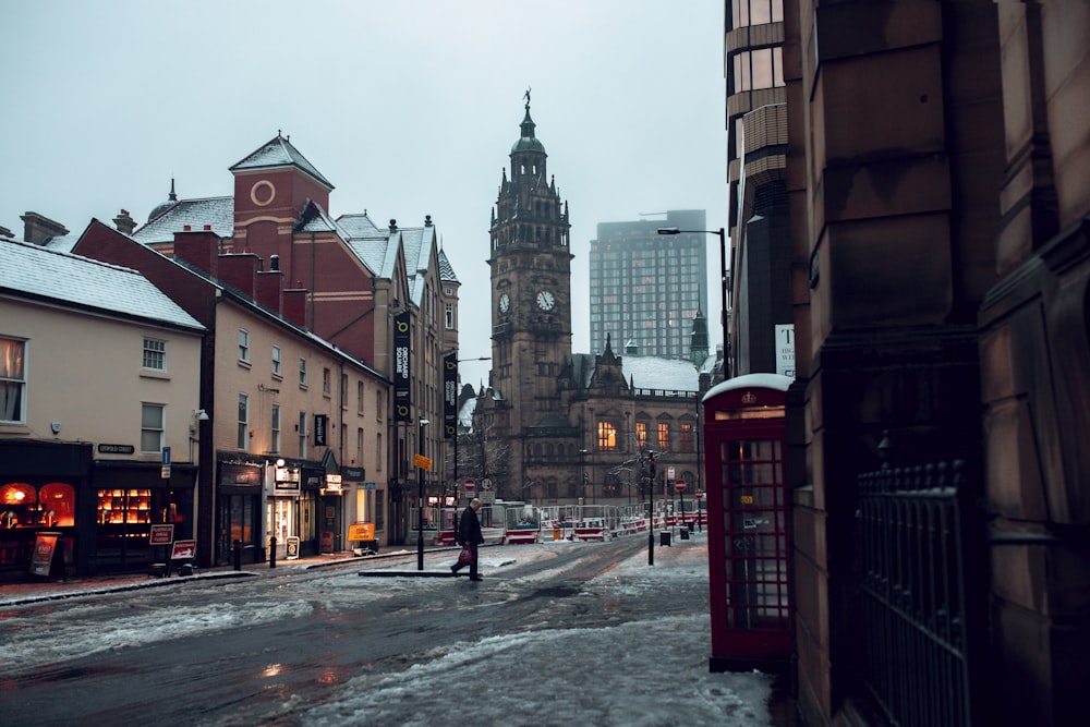 una calle de la ciudad con una torre del reloj al fondo