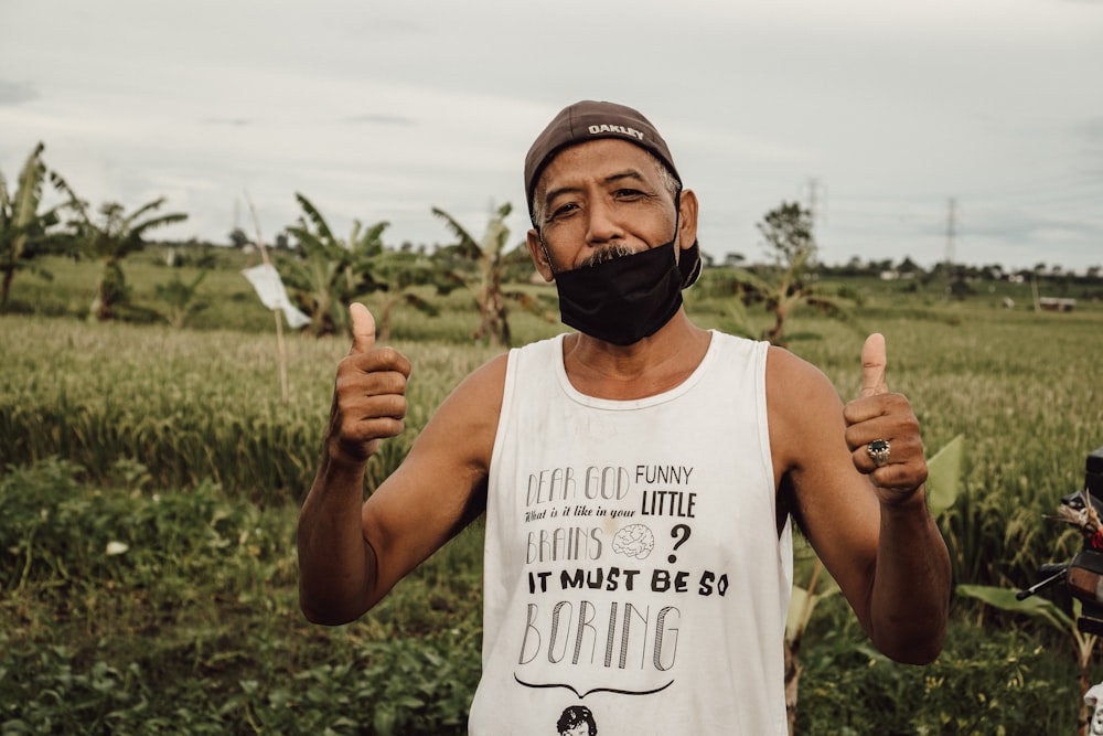 a man with a beard and a moustache gives the thumbs up