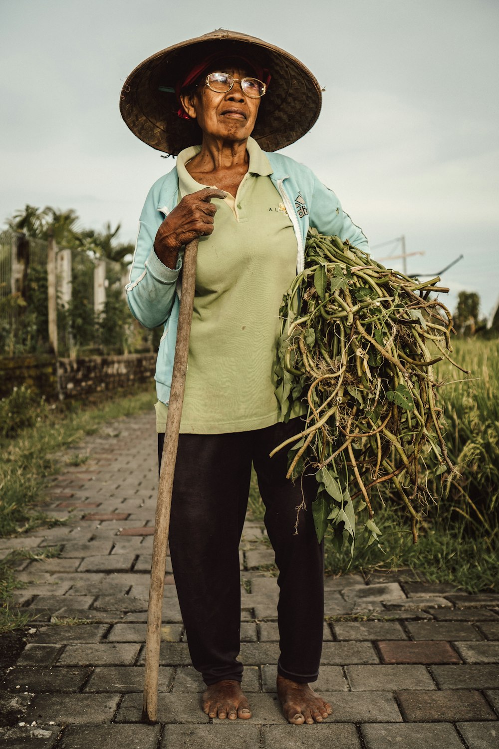 a woman with a straw hat holding a stick