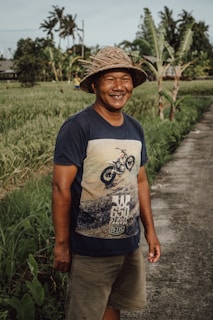 a man wearing a hat standing in a field