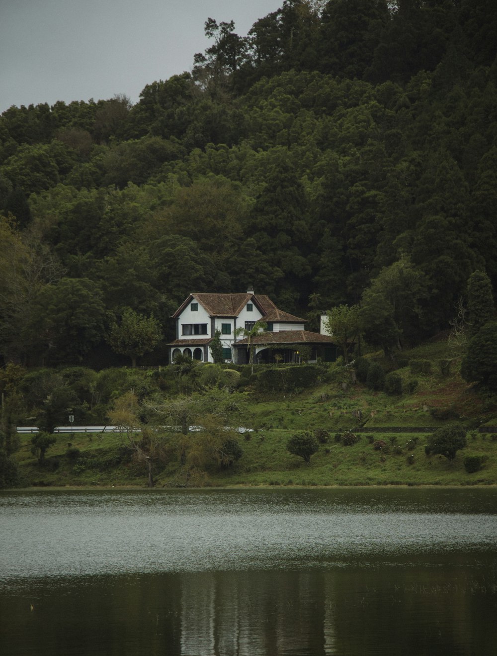 a white house sitting on top of a lush green hillside