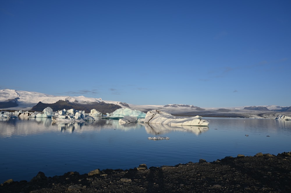 a large body of water with icebergs in the background