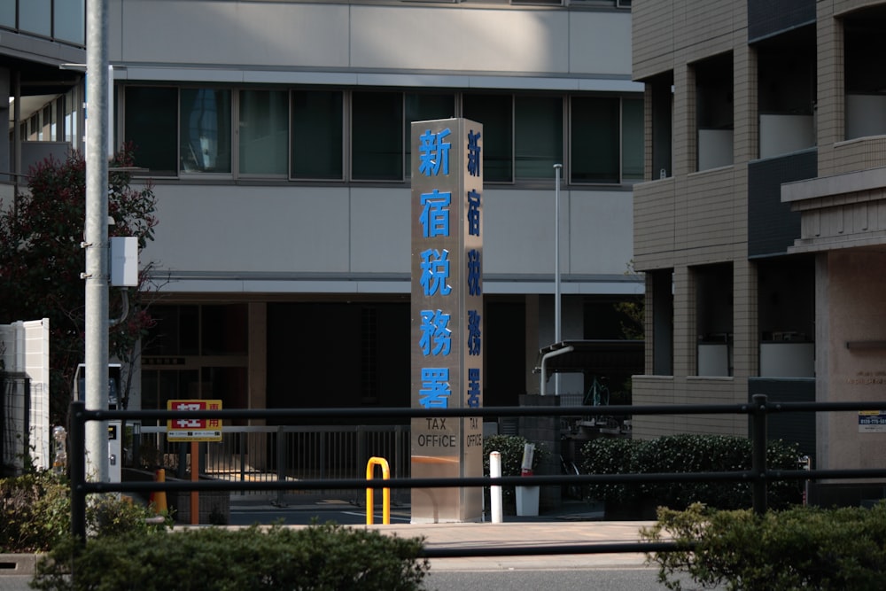 a tall blue sign sitting in front of a tall building