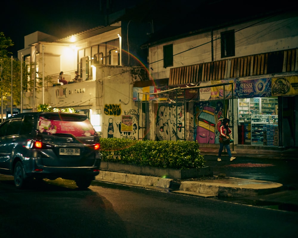 a car parked on the side of a street at night