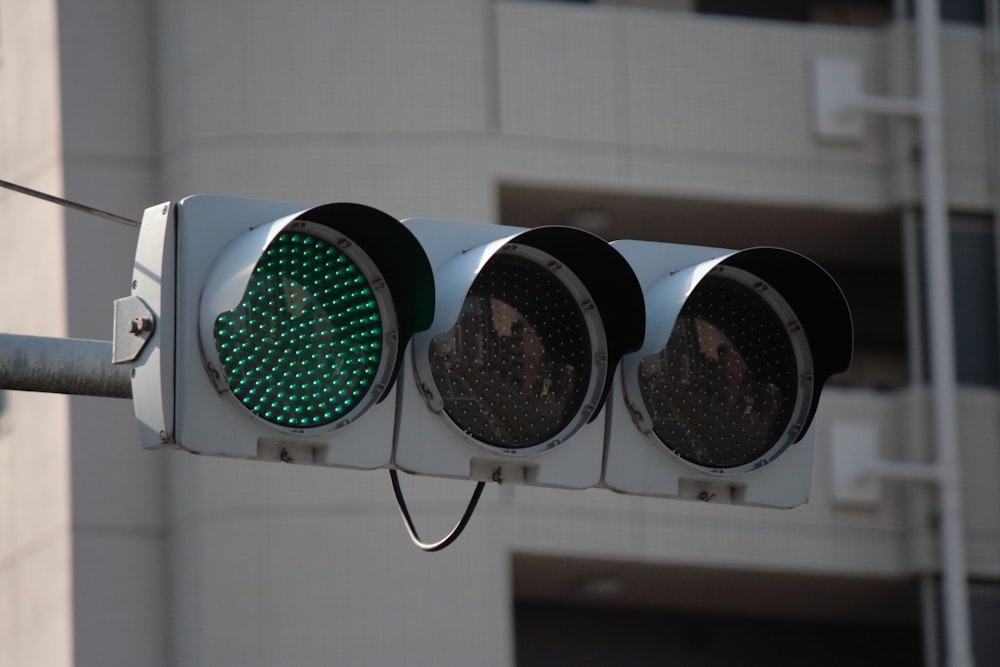 a traffic light with three green lights on it