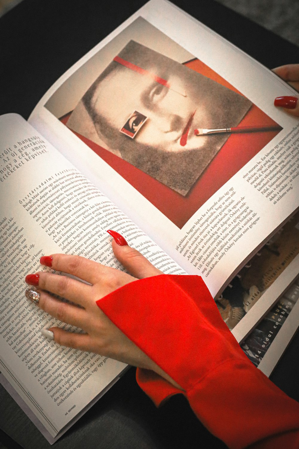 a woman with red nails holding a book