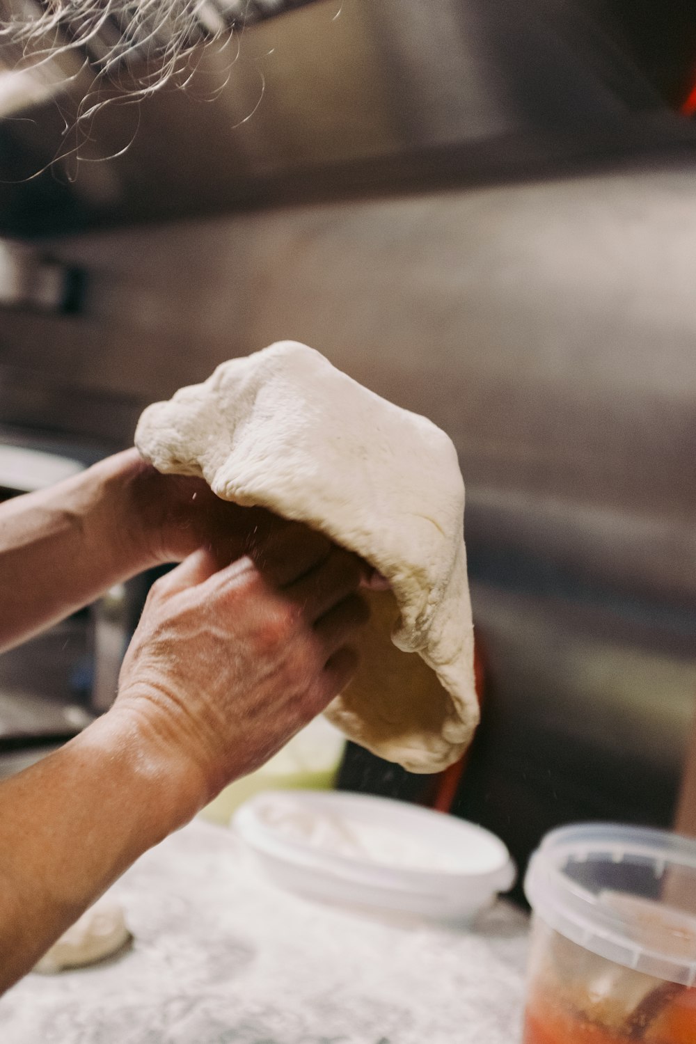 a person is kneading dough in a kitchen
