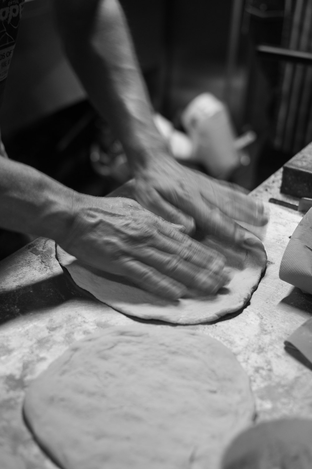 a person kneading dough on top of a table