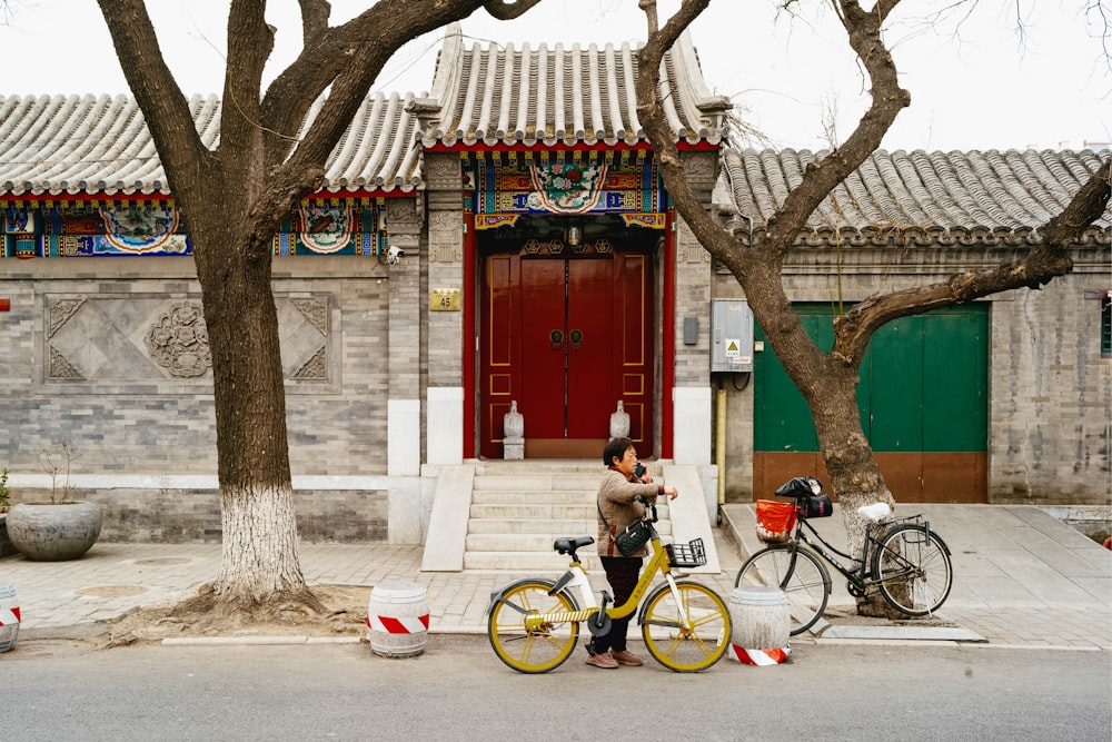 a woman standing next to a yellow bicycle