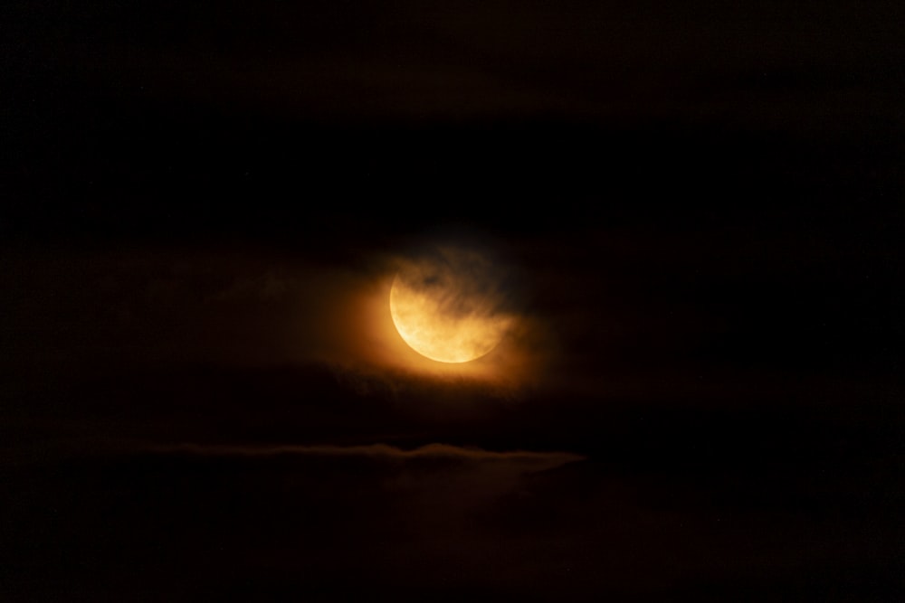 the moon is seen through the clouds during a partial eclipse