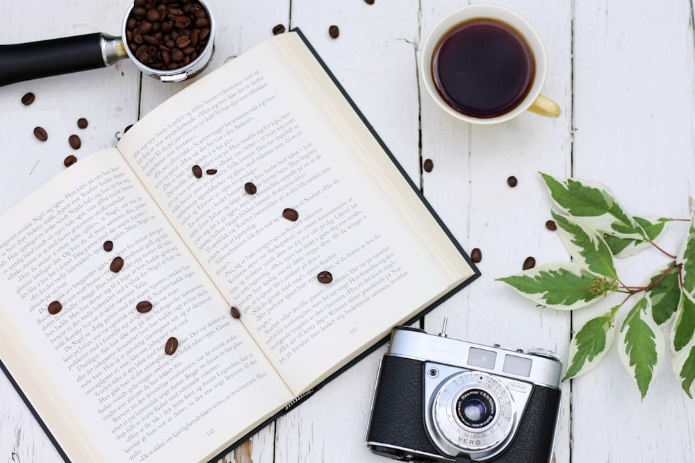 an open book with coffee beans and a camera