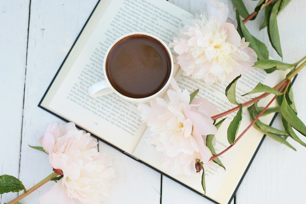 a cup of coffee sitting on top of a book