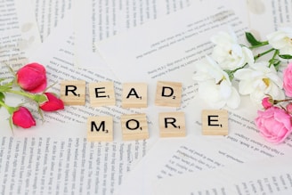 flowers and scrabbles spelling read more on top of a book