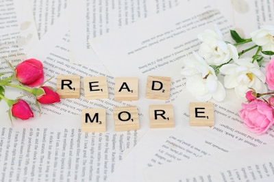 flowers and scrabbles spelling read more on top of a book