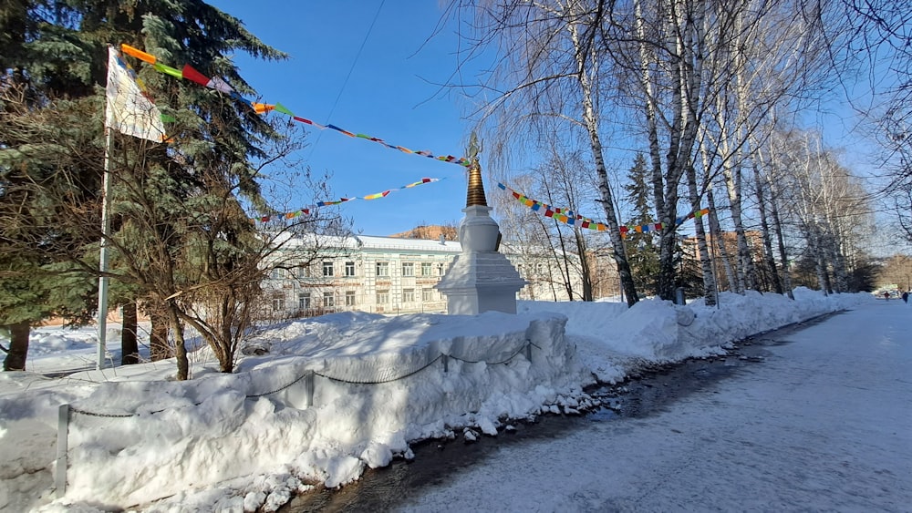 un chemin enneigé avec un bâtiment blanc en arrière-plan